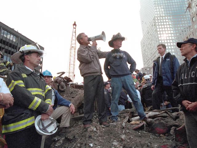 President Bush, standing atop a crumpled fire, speaks to first responders at Ground Zero