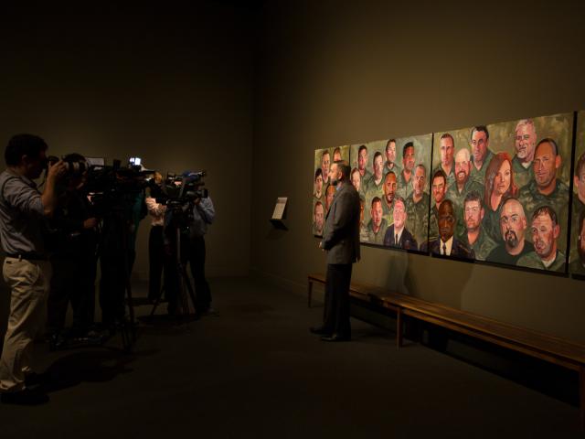 A photo of an interview of a person featured in the multi-panel portrait mural painted by President Bush, part of the 2017 Portraits of Courage exhibit at the George W Bush Library and Museum.