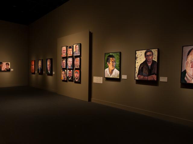A photo of walls lined with portraits painted by President Bush, from the 2017 Portraits of Courage exhibit at the George W Bush Library and Museum.