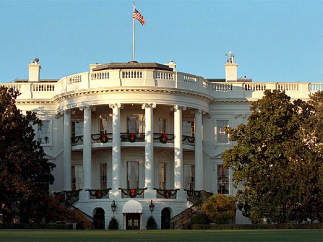 Wreaths adorn the windows of the White House as the sun sets on the South Portico, December 1, 2001.