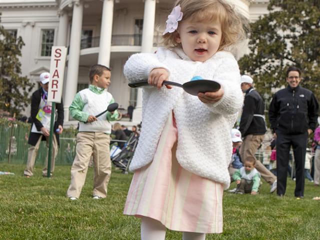 A young child carefully balances her Easter Egg on a spoon, March 24, 2008 on the South Lawn of the White House, during the 2008 White House Easter Egg Roll.