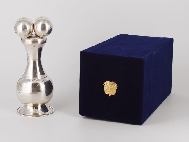 Silver container with removable lid that represents an indigenous artifact; held in a blue velvet hinged box with the coat of arms of Colombia on the lid. Presented to President Bush during a working visit to Washington, D. C. in 2007. Gifted by Alvaro Uribe, President of the Republic of Colombia.