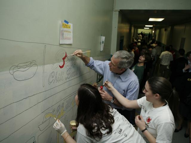 President Bush helps students paint a mural 