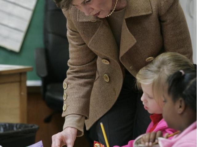 Mrs. Laura Bush works with students at their desks