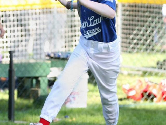 A tee ball player runs across home plate