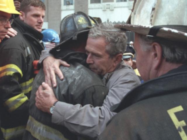 President George W. Bush embraces a firefighter as he speaks to the firefighter.