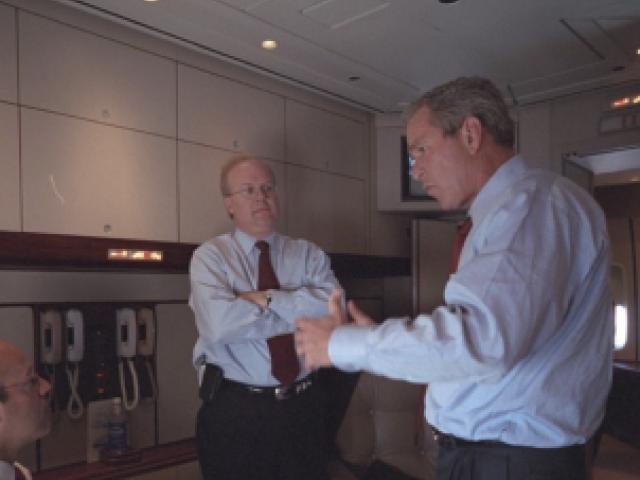 President George W. Bush speaks with Ari Fleischer, left, and Karl Rove aboard Air Force One.