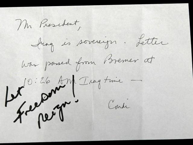 President George W. Bush receives confirmation of Iraqi sovereignty, then wrote, “Let Freedom Reign!” during the opening session of the NATO Summit in Istanbul, Turkey, June 28, 2004.