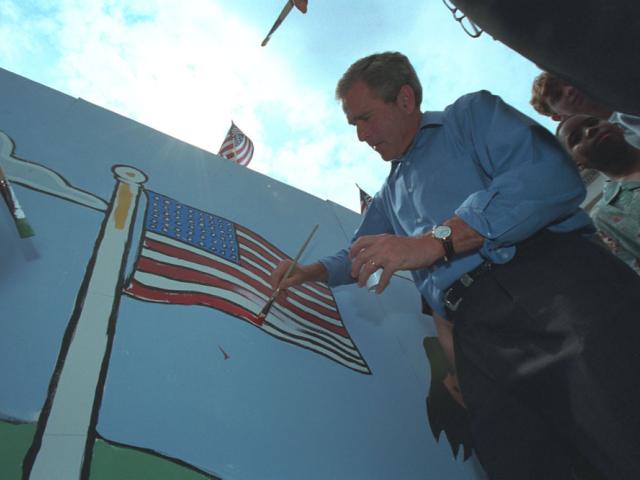 President George W. Bush Paints a Red Stripe on an American Flag Mural in Philadelphia, Pennsylvania on July 4, 2001. P4920-20