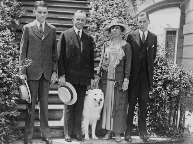 President and Mrs. Coolidge, standing on steps, with their two sons and their pet dog. 1924.