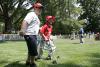 A player is accompanied to first base by a South Lawn buddy.