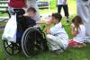 Three children gather to watch tee ball on the South Lawn.