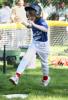 A tee ball player runs across home plate