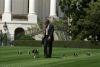 President George H. W. Bush walks onto the White House lawn with his Springer Spaniel, Millie, and Millie's new puppies. One of the puppies is Spot, who would later live at the White House as President George W. Bush's dog. George Bush Presidential Library and Museum. P0237-06.