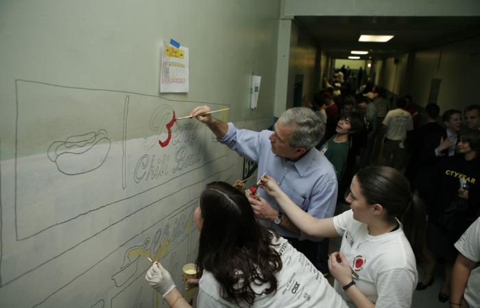President Bush helps students paint a mural 
