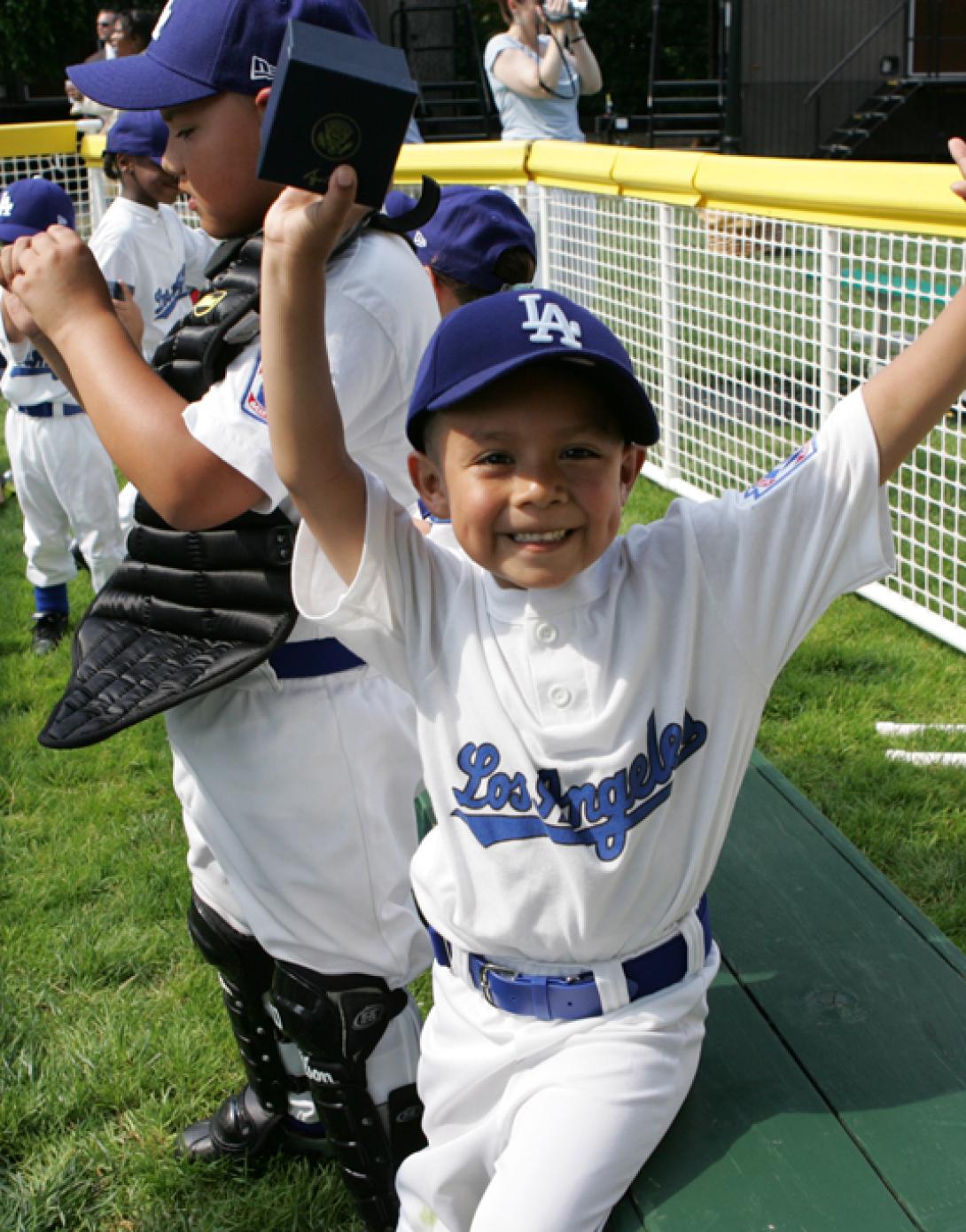 An excited member of the Wrigley Little League Dodgers of Los Angeles shows off his Presidential autographed baseball (P071507JB-0240)