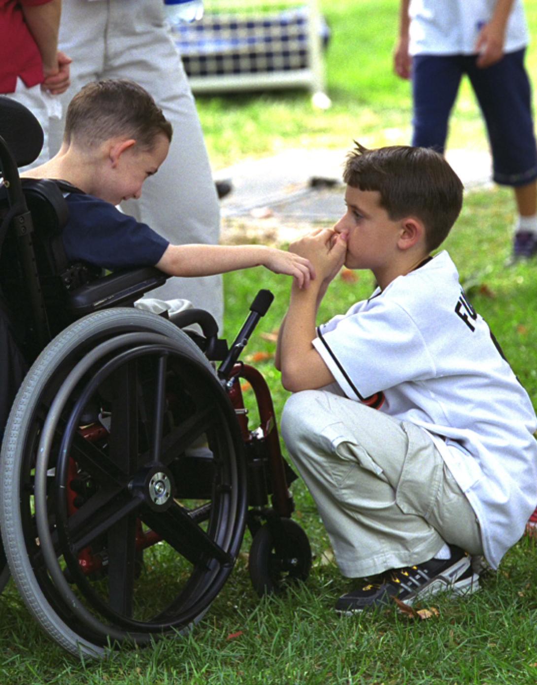 Three children gather to watch tee ball on the South Lawn.