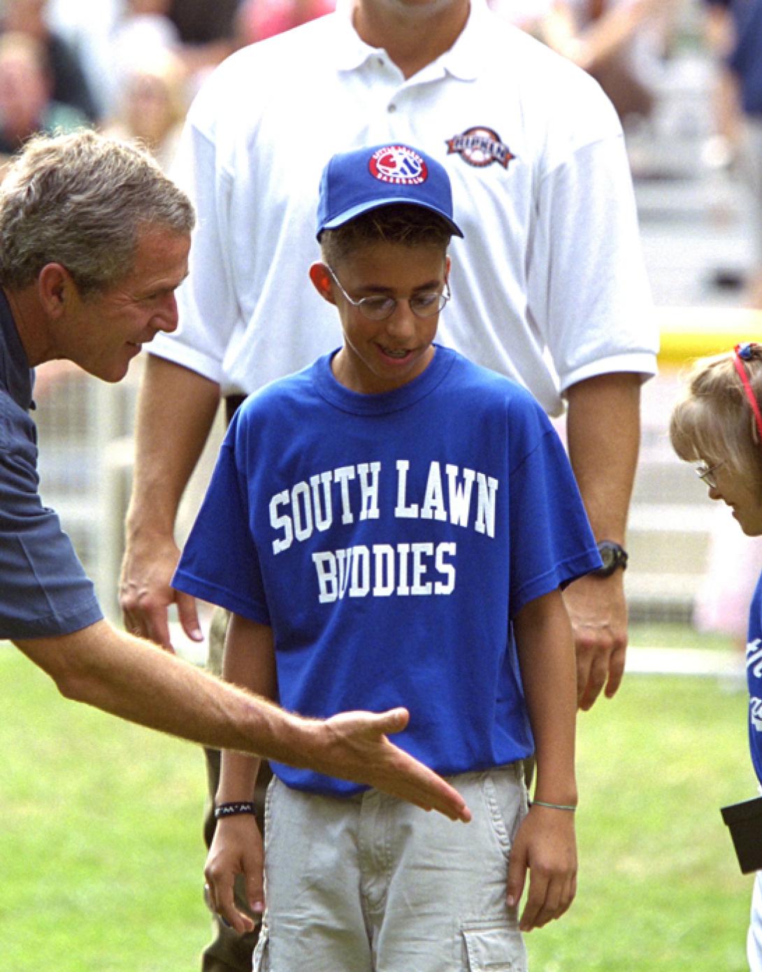President George W. Bush high-fives players during a tee ball game