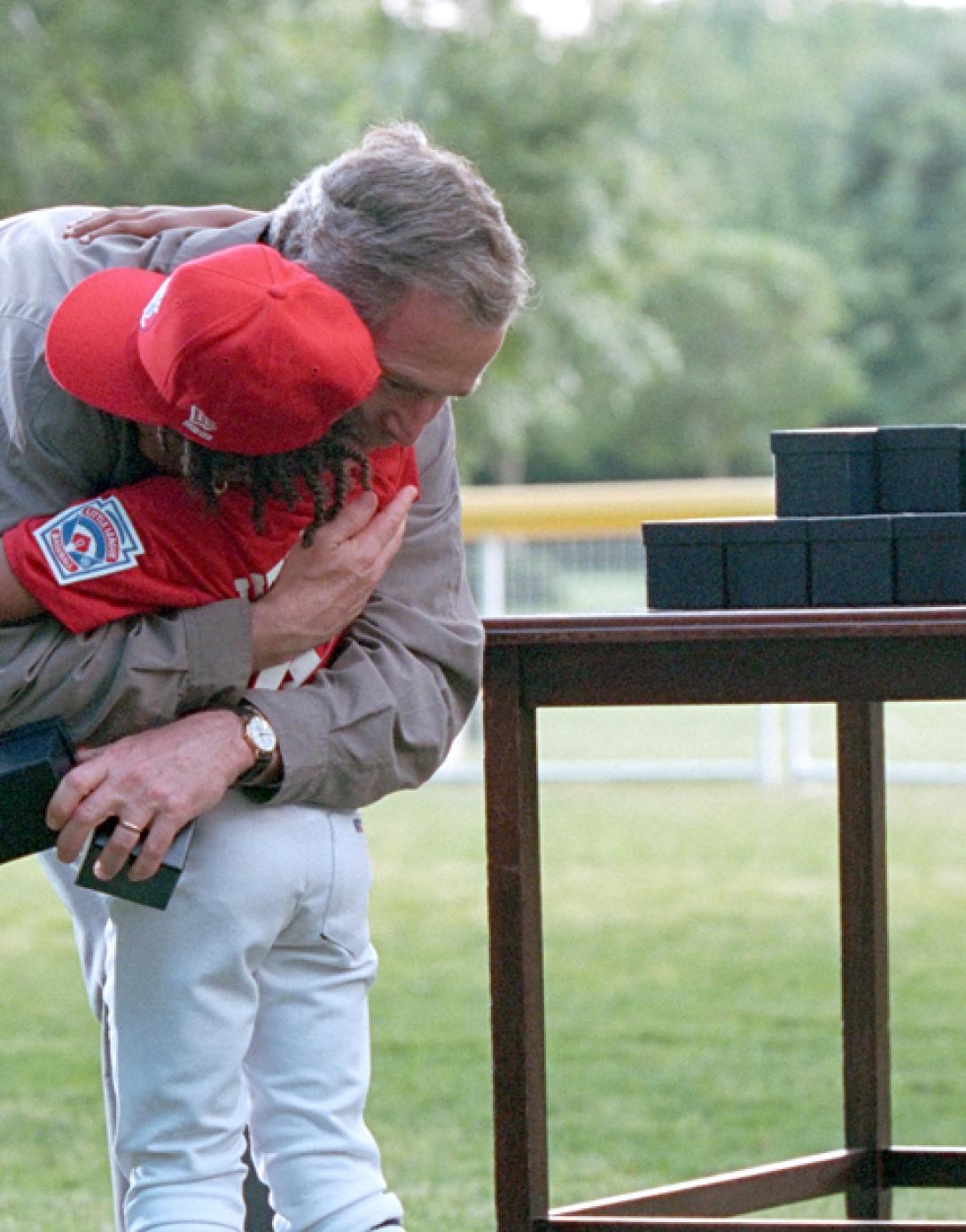 President George W. Bush offers a congratulatory hug as game balls are handed out.