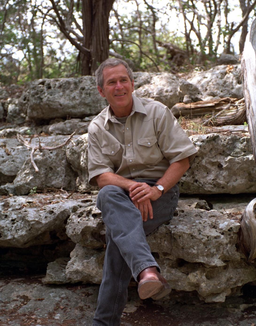 President George W. Bush sits on a rock, August 16, 2001, at Prairie Chapel Ranch in Crawford, Texas. (P6297-29)