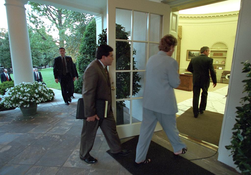 Counselor Karen Hughes and Counsel Alberto Gonzales follow President George W. Bush into the Oval Office, September 11, 2001. (P7110-08)