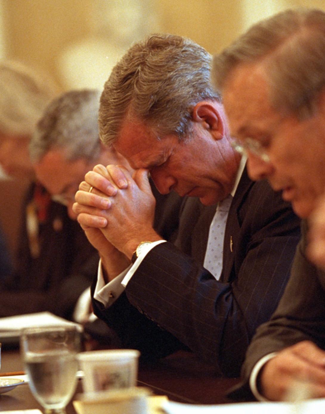 Led in prayer by Secretary of Defense Donald Rumsfeld, right, President George W. Bush joins his Cabinet as they bow their heads, September 14, 2001, before beginning their meeting in the Cabinet Room of the White House. (P7323-09a)