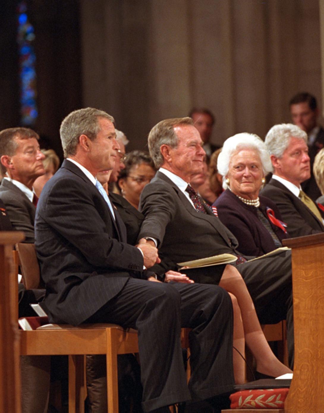 President George W. Bush grasps the hand of his father, former President George H. W. Bush, September 14, 2001, after speaking at the service for America's National Day of Prayer and Remembrance at the National Cathedral in Washington, D.C. (P7338-30)