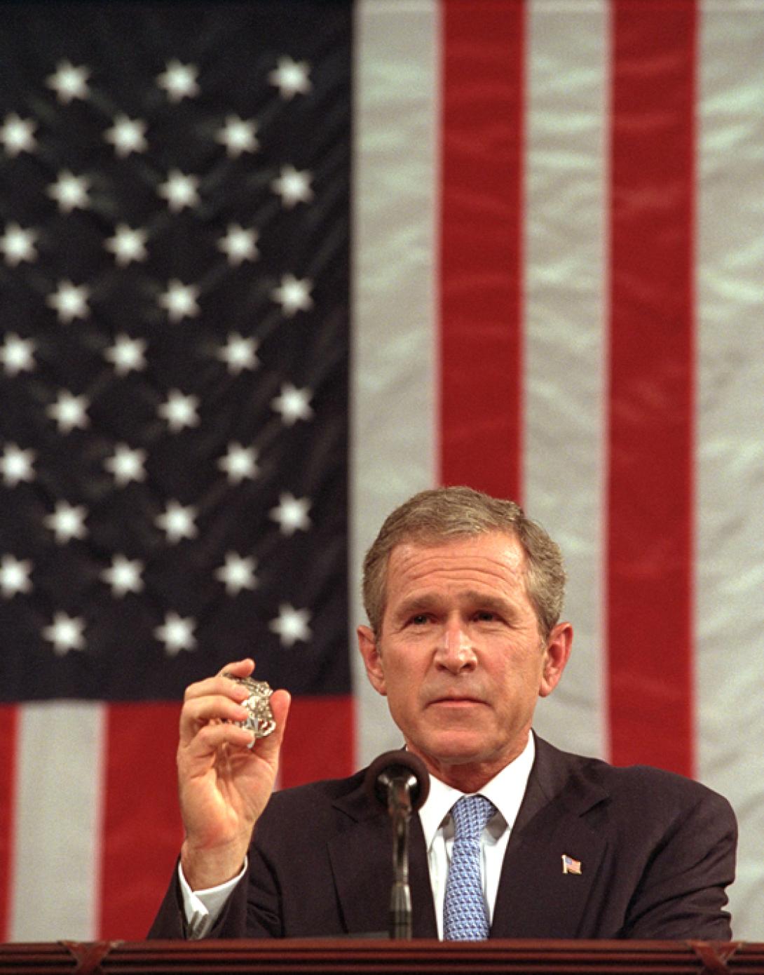 President George W. Bush holds the badge of a Port Authority Police officer killed in the September 11 attacks.