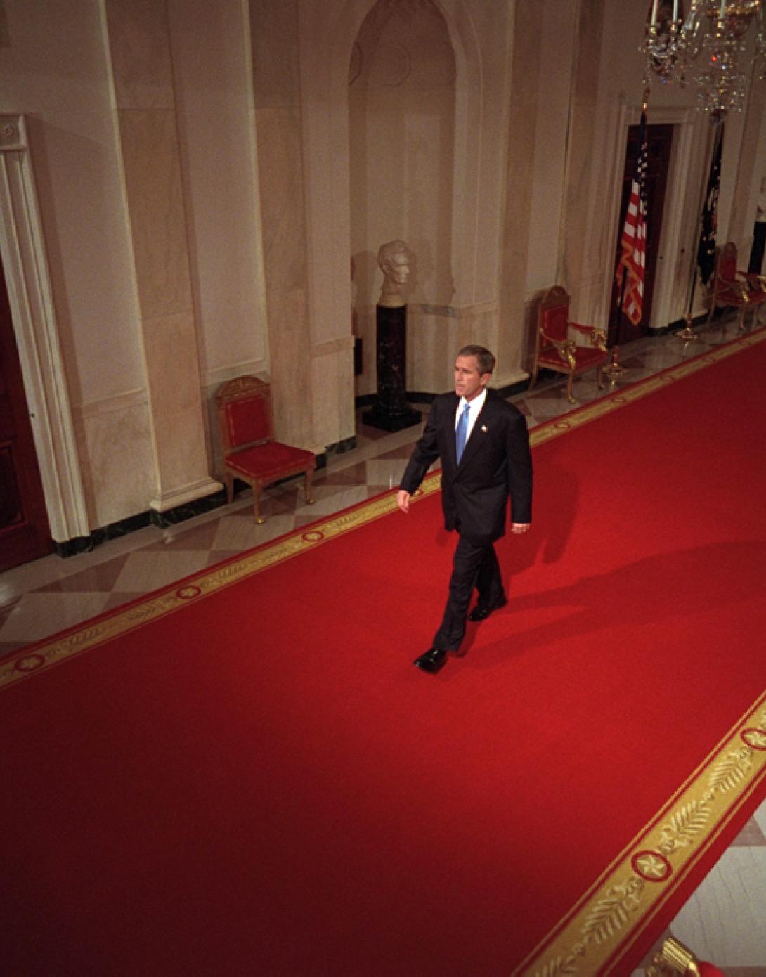 President George W. Bush walks across Cross Hall to the East Room of the White House, October 11, 2001, to give a press conference. (P8468-08)