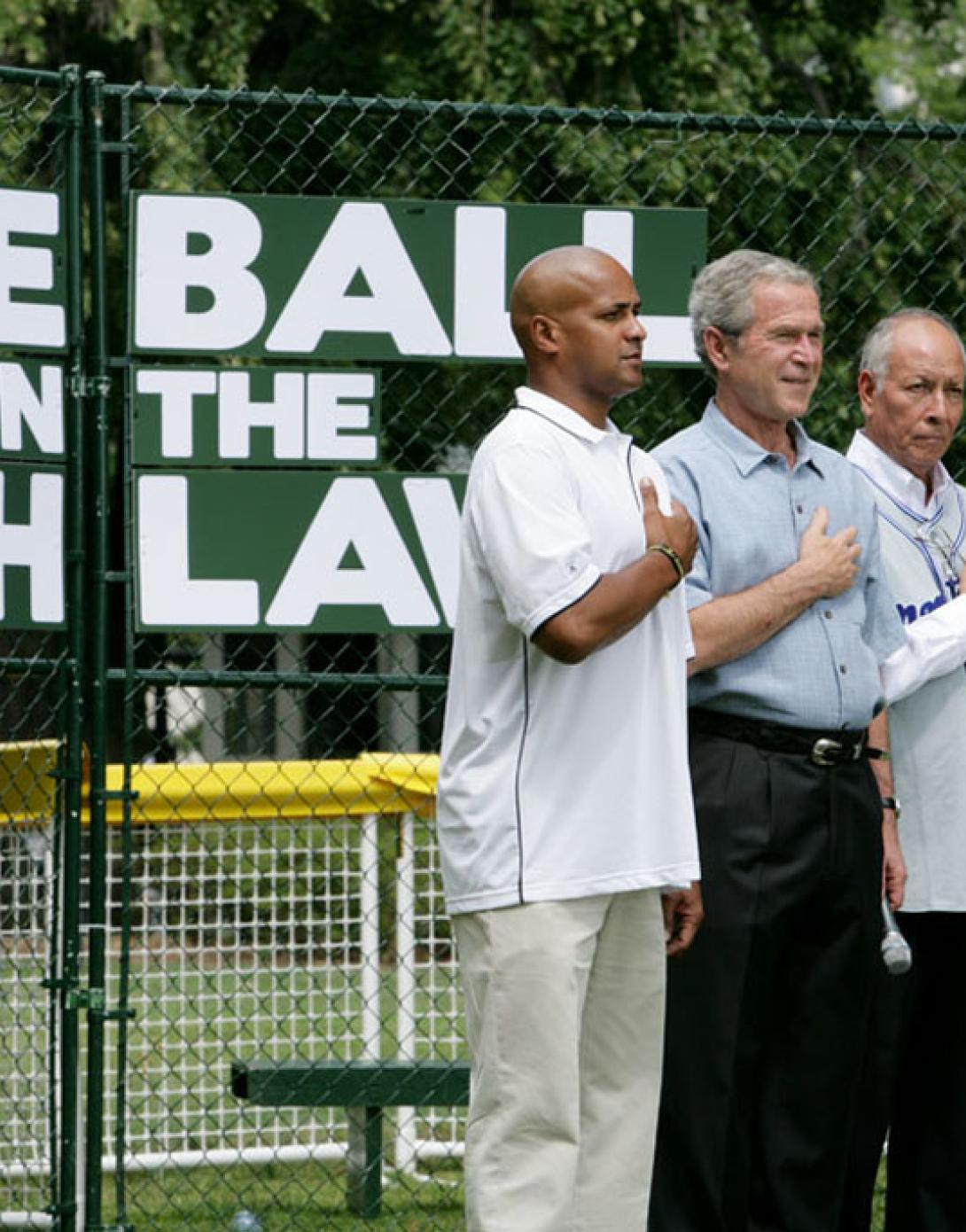 President George W. Bush is joined during the playing of the National Anthem by Roberto Clemente Jr., Angel Macias, and actor Jake T. Austin at Tee Ball on the South Lawn.