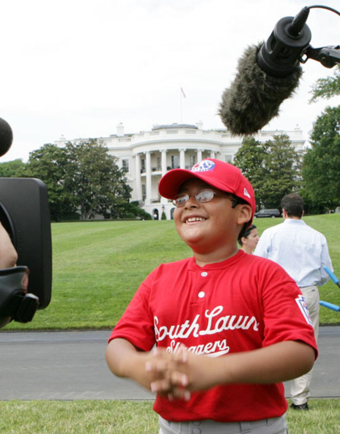 A player with the Cramer Hill Little League Red Sox of Camden, New Jersey, is the center of media attention.
