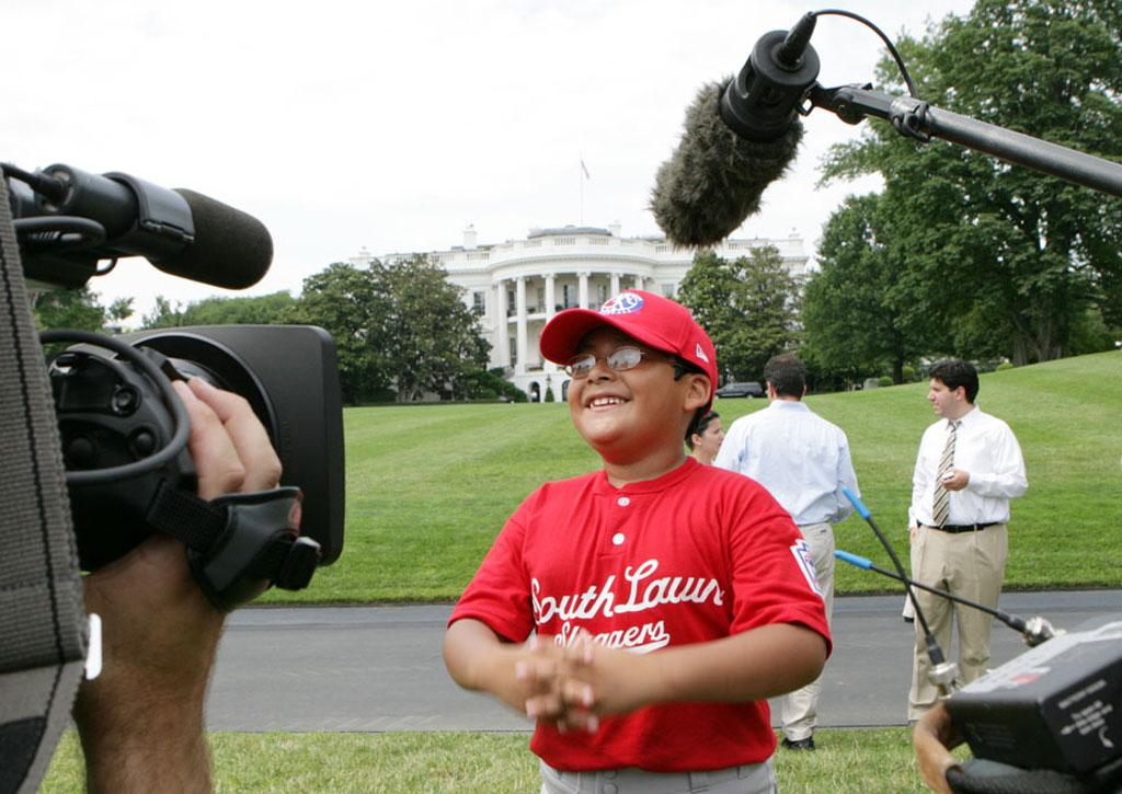 A player with the Cramer Hill Little League Red Sox of Camden, New Jersey, is the center of media attention.