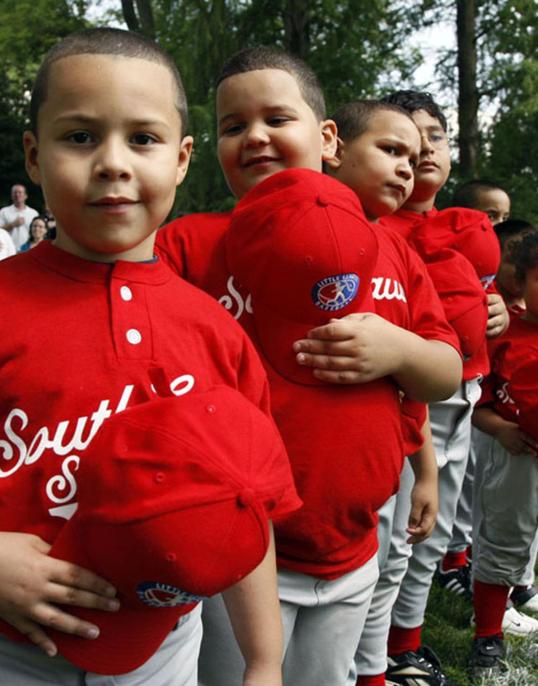 Players hold their hats over their hearts during the singing of the National Anthem.