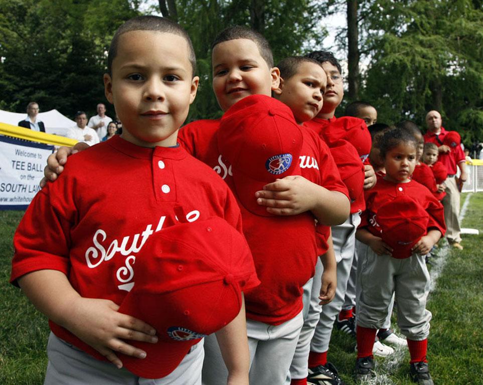 Players hold their hats over their hearts during the singing of the National Anthem.