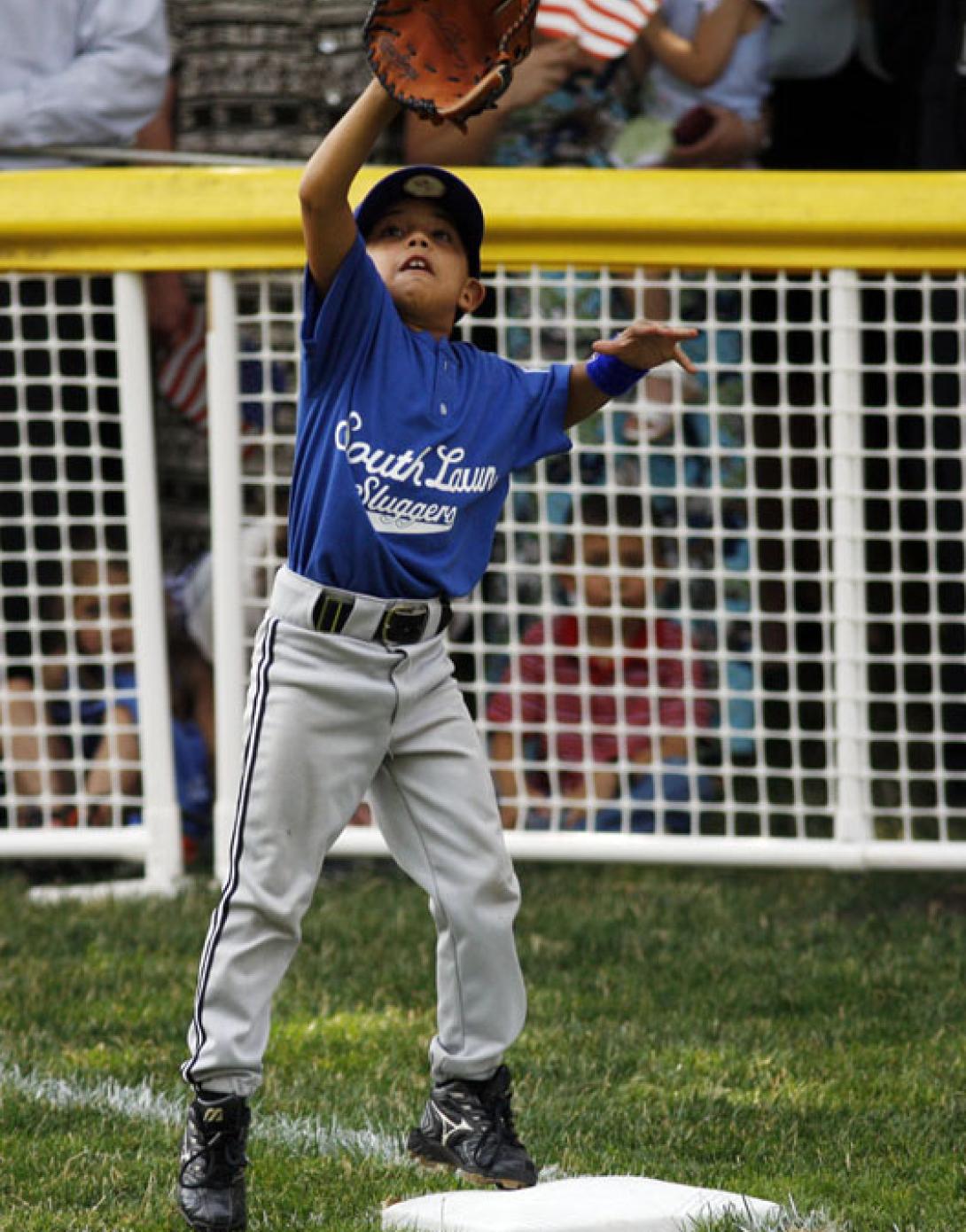 The first base player catches a ball in his glove.