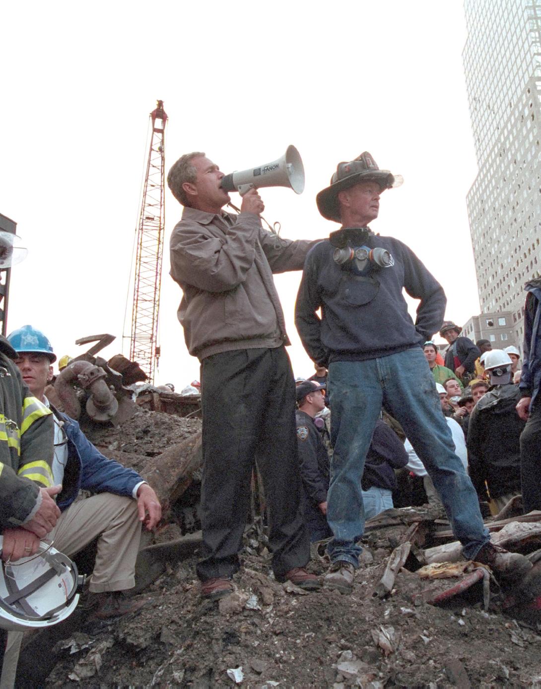 President Bush, standing atop a crumpled fire, speaks to first responders at Ground Zero