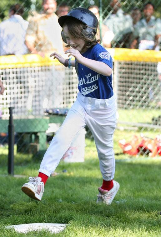 A tee ball player runs across home plate