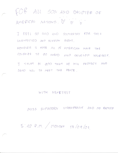 Supaporn Vijanprasit and family from The Kingdom of Thailand write a message of sympathy in a condolence book.