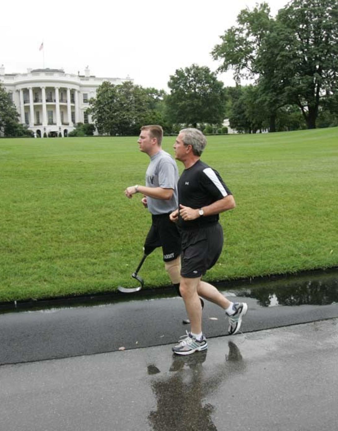 President George W. Bush runs with U.S. Army Staff Sergeant Christian Bagge of Oregon, on the South Lawn, June 27, 2006. President Bush met Sgt. Bagge at Brooke Army Medical Center January 1, 2006, where he promised to run with Sgt. Bagge.