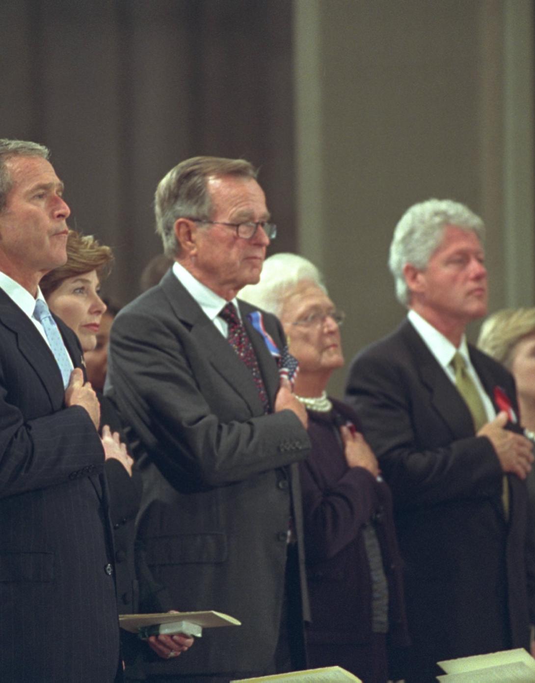 President George W. Bush, Mrs. Laura Bush, Former President George H. W. Bush, Mrs. Barbara Bush, Former President Bill Clinton, Sen. Hillary Rodham Clinton, and Chelsea Clinton, stand with hands over hearts for the Pledge of Allegiance during the National Day of Prayer and Remembrance service at the National Cathedral in Washington, DC.