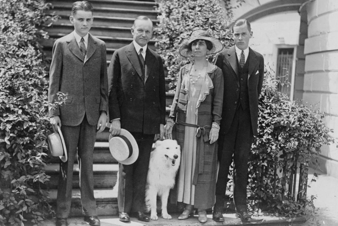 President and Mrs. Coolidge, standing on steps, with their two sons and their pet dog. 1924.